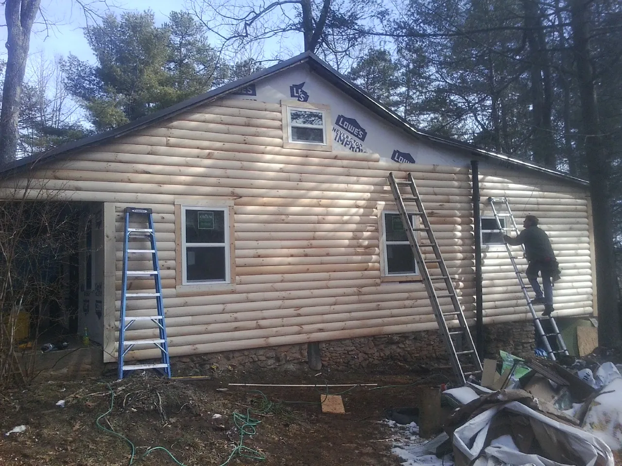 Ladders set against fresh log siding during an exterior remodel in Chandlersville
