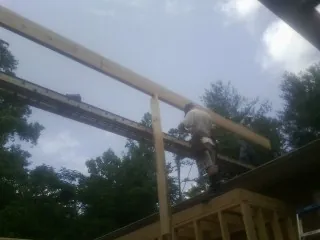Carpenter setting a ridge beam over a new addition frame — Ice Dam Removal by Roofing Brothers in Chandlersville