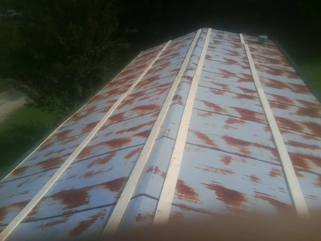 Rusted metal roof panels with new wood purlins before replacement — Storm Damage Roof Repair in Chandlersville by Roofing Brothers