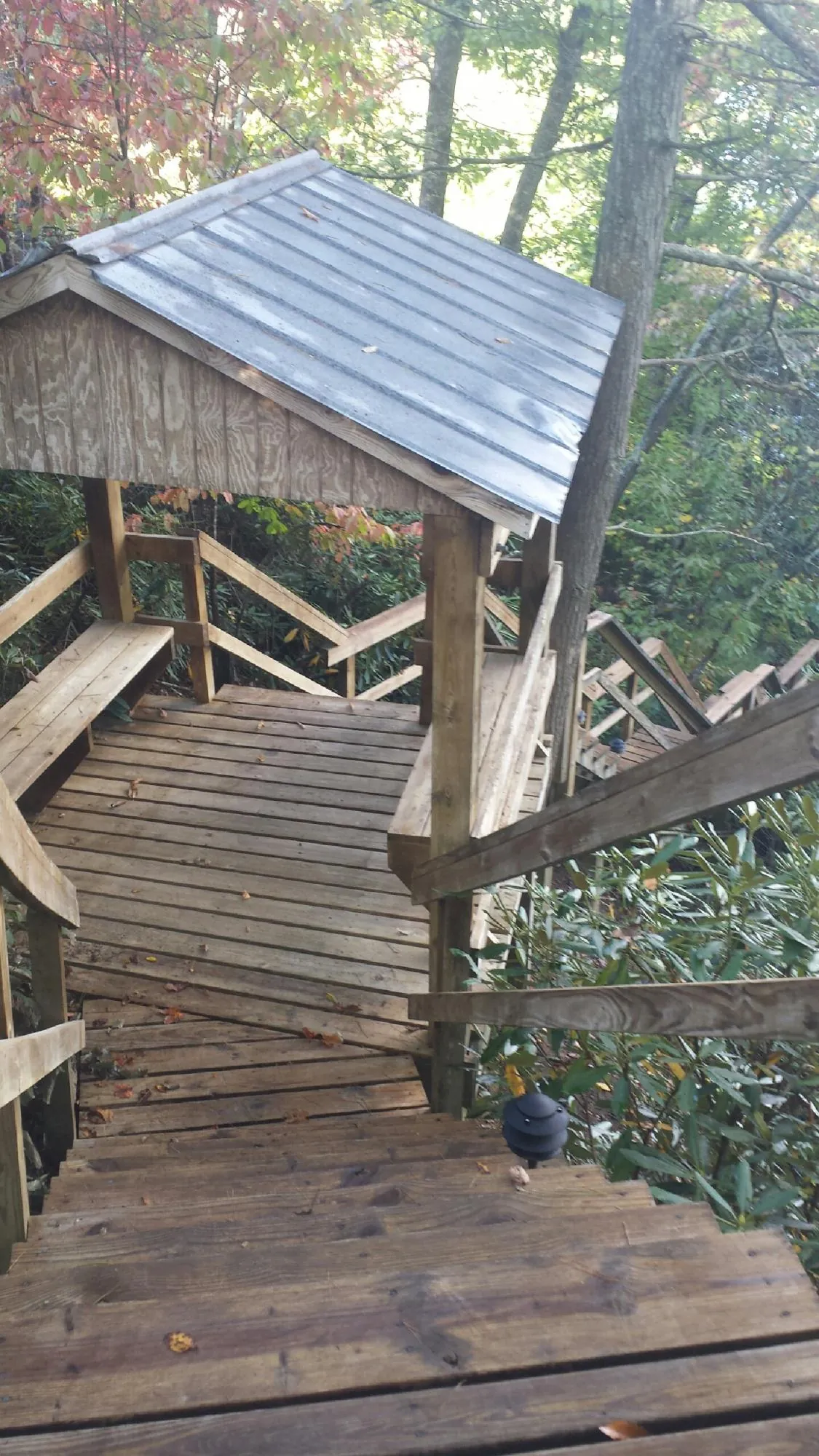 Metal roofed shelter over wooden steps on a wooded walkway — Skylight Repair & Installation work by our crew in Chandlersville