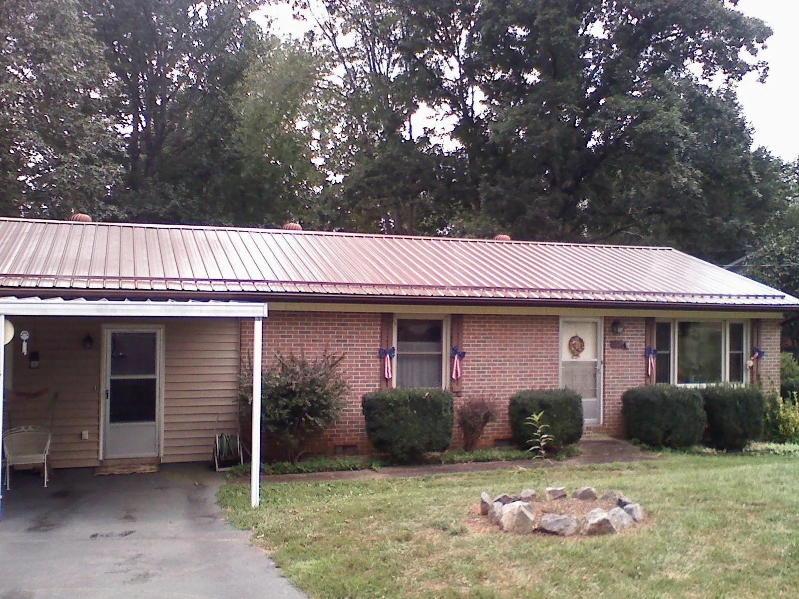 Bronze metal roof and carport on a brick ranch home — Roof Repair work by our crew in Chandlersville